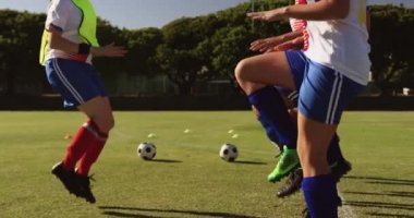Futbol sahasında yerde çalışan çeşitli kadın futbol takımının yan görünümü. 4k