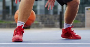 Beyaz basketbolcu basketbol sahasında basketbol oynarken düşük bölümü. Basketbol 4k'den kaçıyor.