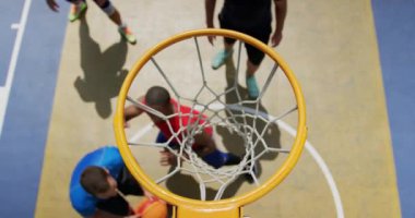 Basketbol sahasında basketbol oynayan çok ırklı basketbolcuların yüksek açı görünümü. Onlar bir gol 4k yapıyoruz