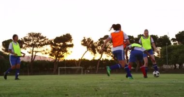 Futbol sahasında farklı takımlarda oynarken topu geçen farklı kadın futbol takımı ön görünümü. 4k