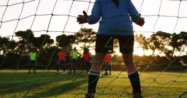 Arka dan bir golü niçin durdurmaya çalışan bir golü niçin farklı bir şekilde duran sarı-turuncu yelekli kadın futbol takımı ise futbol sahasında ayakta duruyor. 4k