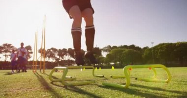 Futbol sahasında ekipman ile egzersizler yapan çeşitli kadın futbolcuların düşük açı görünümü. 4k