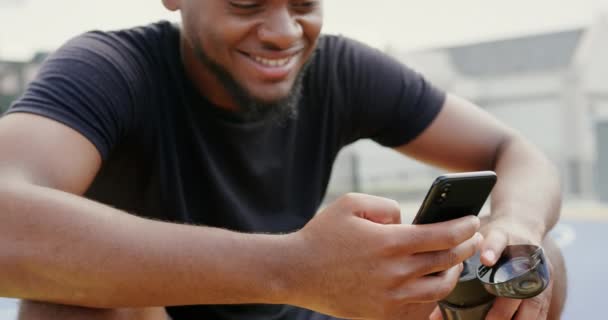 Frontansicht Eines Afrikanisch Amerikanischen Basketballspielers Der Sein Mobiltelefon Basketballfeld Benutzt — Stockvideo