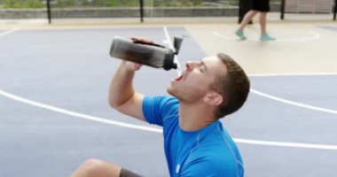 Basketbol kortunda Kafkas basketbol oyuncusu içme suyu ön görünümü. O yorgun ve 4k tükenmiş