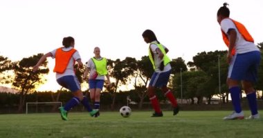 Kafkas kadın futbolcunun ön görünümü, futbol sahasında karışık ırklı kadın futbolcuyla mücadele ediyor. 4k