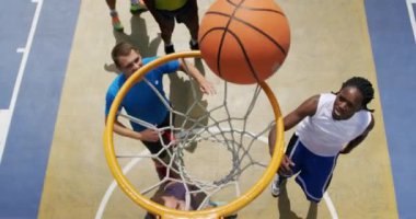 Basketbol sahasında basketbol oynayan çok ırklı basketbolcuların yüksek açı görünümü. Onlar bir gol 4k yapıyoruz