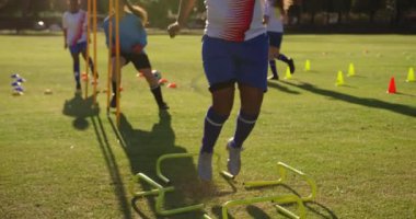 Futbol sahasında ekipman ile egzersiz ler yapan çeşitli kadın futbolcuların ön görünümü. 4k