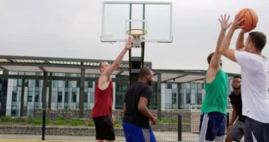 Basketbol sahasında basketbol oynayan çok ırklı basketbolcuların arka görünümü. Onlar bir gol 4k yapıyoruz
