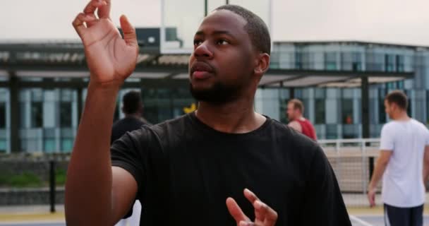 非裔美国人篮球运动员在球场上打篮球的正面观点 他在4K的手指上旋转篮球 — 图库视频影像