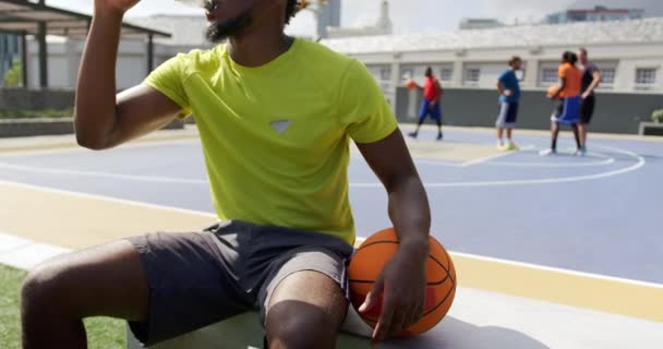 Vista Frontal Del Jugador Baloncesto Afroamericano Vertiendo Agua Cara Cancha — Vídeos de Stock