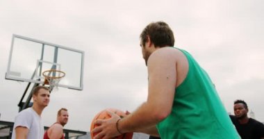Basketbol sahasında basketbol potasında basketbol atan Kafkas basketbolcu düşük açı görünümü. Birlikte 4k oynuyorlar.