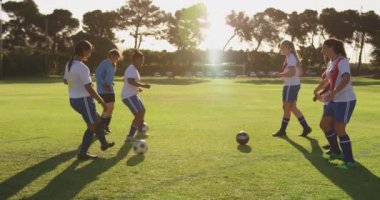 Farklı kadın futbol takımının yan görünümü antrenmanfutbol sahasında birbirlerine topu geçmek için. 4k