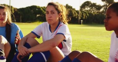 Mola futbol sahasında konuşurken ve gülüyor çeşitli kadın futbol takımı ön görünümü. 4k