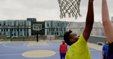Basketbol sahasında basketbol oynayan çok ırklı basketbolcuların düşük açılı görünümü. Onlar bir gol 4k yapıyoruz