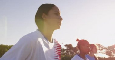 Karışık ırk kadın futbolcular Futbol sahasında kafası ile topu çekim Yan görünümü. 4k