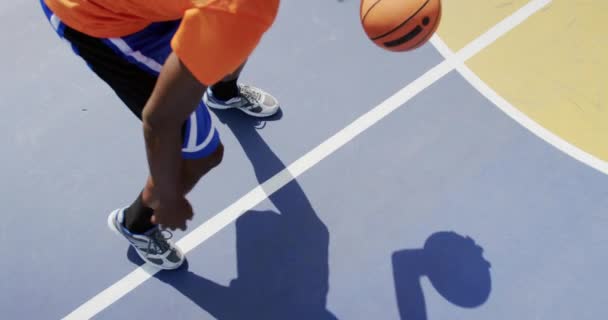 High angle view of African american basketball player playing basketball in basketball court. He is dodging a basketball 4k — Stock Footage High Angle View African American Basketball Player Playing Basketball Basketball Stock Footage