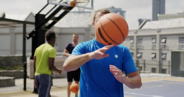 白人篮球运动员站在球场上与篮球的正面视图 他正在看4K相机 — 图库视频影像