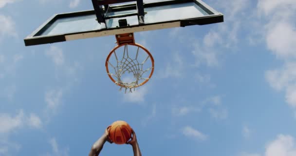 Low angle view of African american basketball player playing basketball in basketball court. He is making a goal 4k — Stock Footage Low Angle View African American Basketball Player Playing Basketball Basketball Stock Video