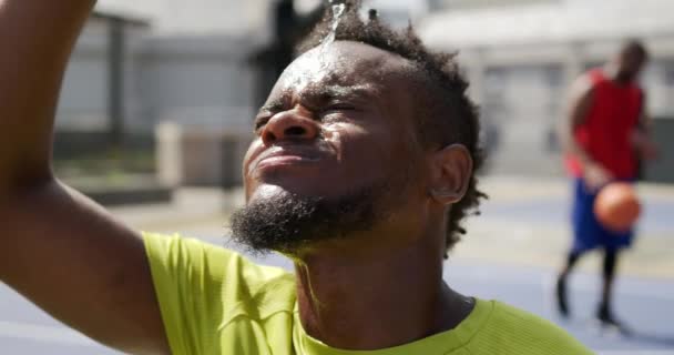 Vooraanzicht Van Afro Amerikaanse Basketbalspeler Gieten Water Gezicht Basketbalveld Hij — Stockvideo