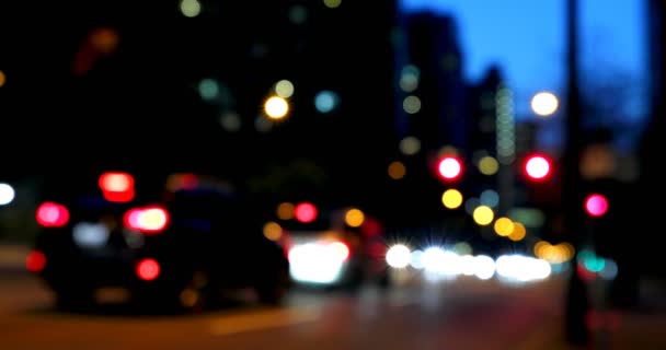 Vue de face du bokeh coloré des feux de voiture dans la rue la nuit. Les véhicules s'arrêtent au feu 4k 