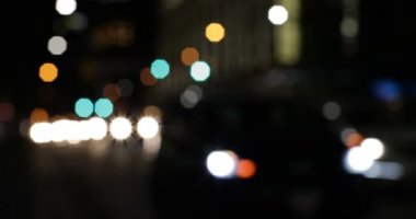 Gece sokakta araba ışıkları renkli bokeh ön görünümü. Yolda 4k sürme Arabalar