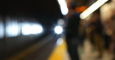 Metro platformunda tren bekleyen bulanık yolcular. Platform 4k'a gelen tren