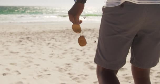 Milieu Afro Américain Marchant Sur Plage Tient Des Lunettes Soleil — Video