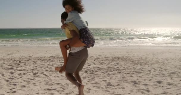 Vista Lateral Del Hombre Afroamericano Dando Paseo Cuestas Mujer Playa — Vídeo de stock