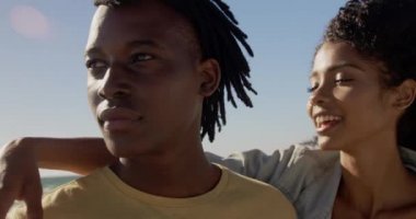 Sahilde birbirlerini kucaklayan Afrikalı-Amerikalı çiftin ön görünümü. Onlar 4k gülümsüyor