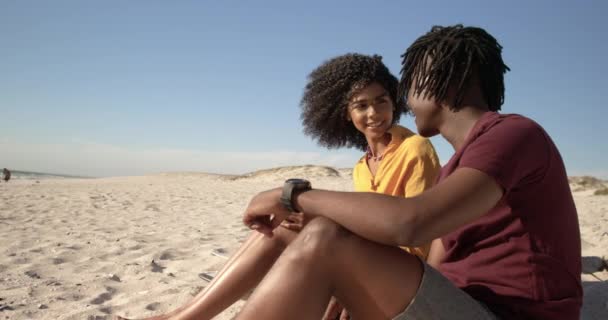 ビーチで抱き合うアフリカ系アメリカ人カップルのサイドビュー 笑顔で4K — ストック動画