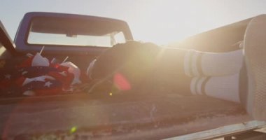 Sahilde kamyonette dinlenen Afro-Amerikan adamın düşük bölümü. O bacaklar 4k geçti