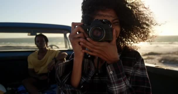 Sahilde Bir Kamyonette Dijital Kamera Ile Fotoğraf Çeken Afro Amerikan — Stok video