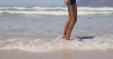 Genç Afrikalı-Amerikalı kadın güneş altında sahilde dans düşük bölümü. O eğleniyor 4k