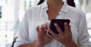 Ofisteki bir lobide yürüyen merdivenin yanında cep telefonu kullanan bir iş kadınının orta bölümü. 4k 'ye mesaj atıyor.