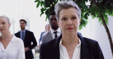 Ofisteki lobide yürüyen çeşitli iş adamlarının ön görüntüsü. 4k