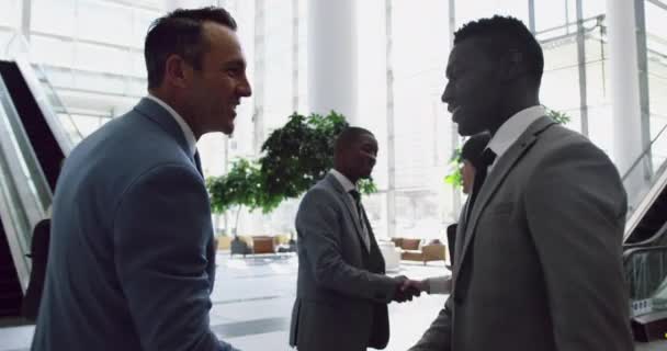 商业人士在办公室大堂里互相交流的侧面观点 他们在握手 — 图库视频影像