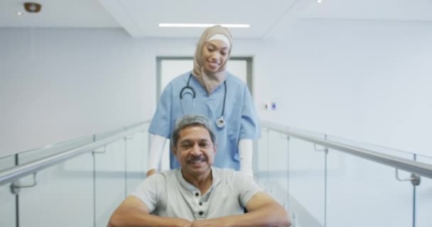 Rastreamento Reverso Tiro Jovem Mestiço Médico Feminino Empurrando Paciente Masculino — Vídeo de Stock