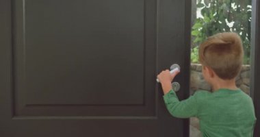 Beyaz çocuğun kapıyı açıp rahat bir evde babasını kucaklamasının arka manzarası. Onlar 4k gülümsüyor