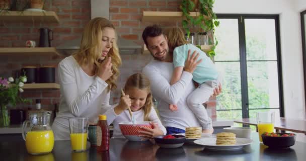 快適な家庭でキッチンでワークトップに食べ物を準備する白人家族の正面図 笑顔で4K — ストック動画