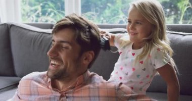 Genç Kafkas kızının evde ki kanepede babalarının saçlarını taradığını görmek. Onlar gülümsüyor ve birlikte 4k oturuyor