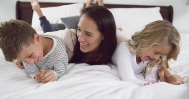 Evde yatak odasında çocuklarıyla oynayan Kafkas anne ön görünümü. Onlar gülümsüyor ve eğleniyor4k