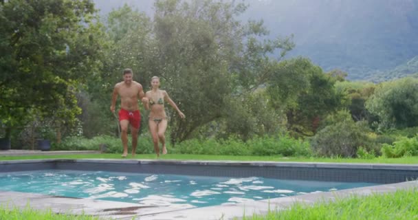 Vorderansicht Eines Kaukasischen Paares Das Zusammen Schwimmbad Des Resorts Springt — Stockvideo