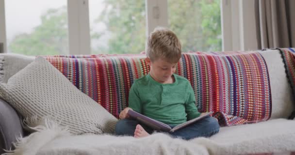 Vista Frontal Del Niño Caucásico Leyendo Libro Cuentos Sala Estar — Vídeo de stock