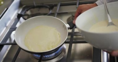 Evdeki mutfakta yemek pişiren adamın yakın çekimi.