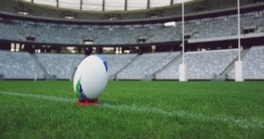 Stadyumdaki çimlere yakın ragbi topu. Arka plandaki boş stadyum 4k