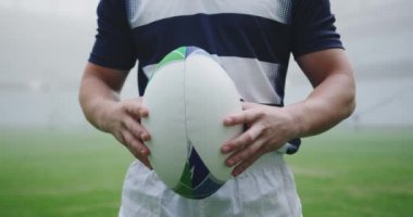 Kafkas erkek rugby oyuncusunun orta bölümü stadyumda rugby topu tutuyor. Arka planda sis 4k