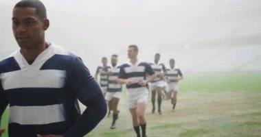 Stadyumda koşan çeşitli erkek rugby oyuncularının ön görüntüsü. 4 km ısınıyorlar.