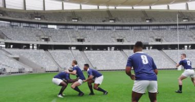 Stadyumda rugby oynayan çeşitli erkek rugby oyuncularının yan görüntüsü. 4K ragbi topunu geçiyorlar.