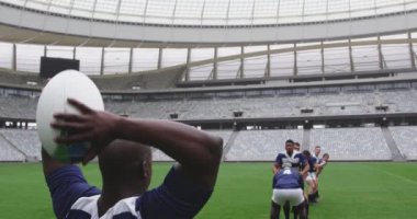 Stadyumda rugby oynayan çeşitli erkek rugby oyuncularının ön görüntüsü. 4K ragbi topunu geçiyorlar.