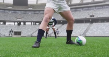 Beyazlı erkek oyuncunun yakın plan fotoğrafları stadyumda rugby topunu geçiyor. Birlikte 4K oynuyorlar.
